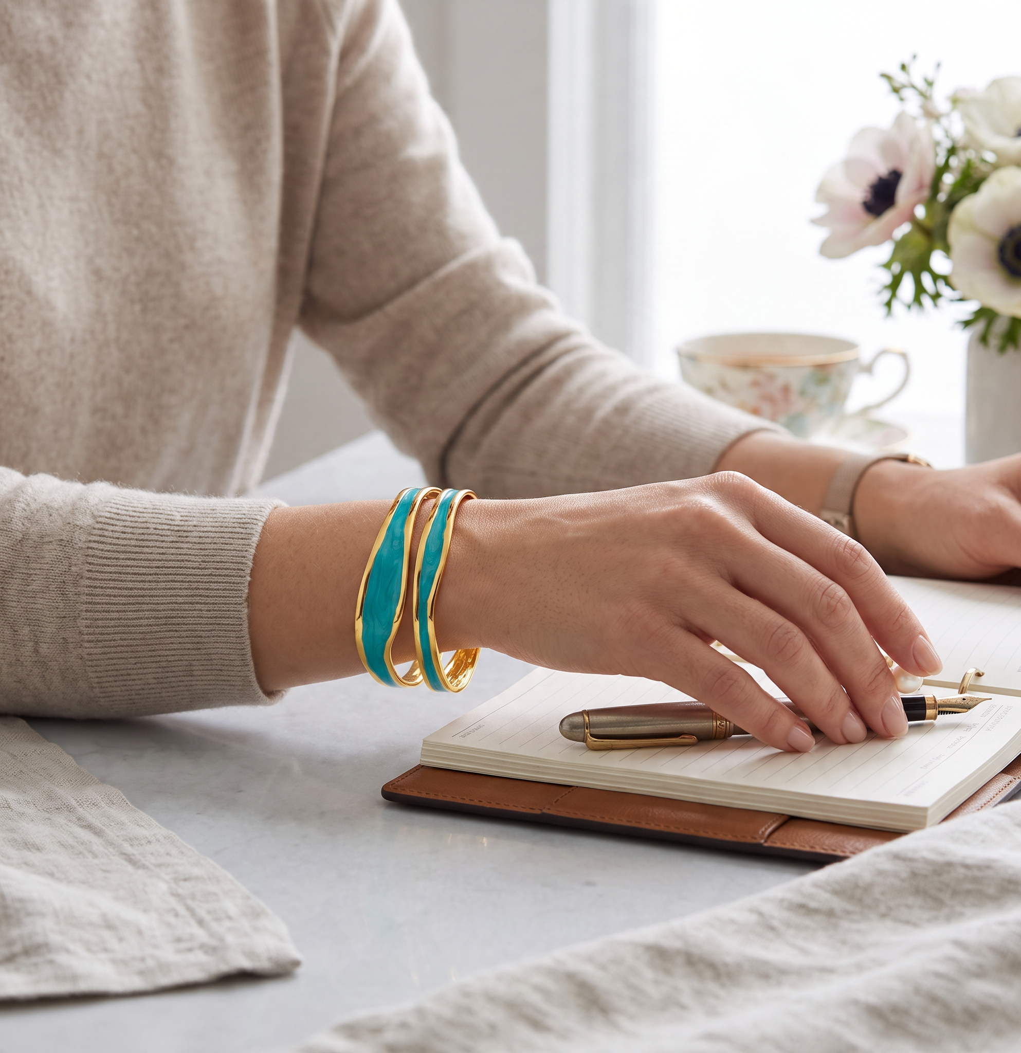 CameroonJewels Ciel d'Afrique adjustable bangle in 18K gold-plated steel with deep blue enamel on a woman's wrist.
