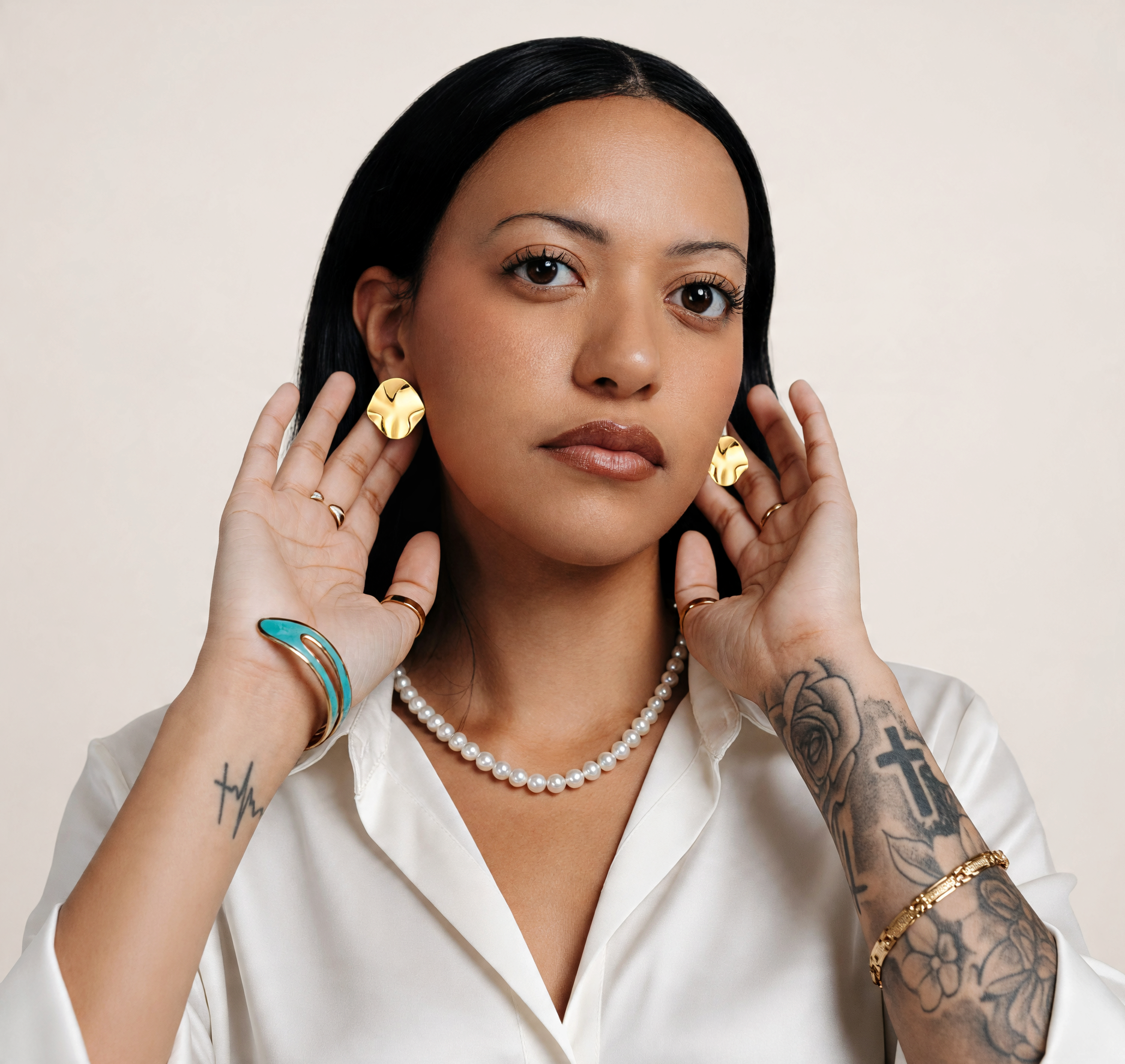 CameroonJewels Cercle d'Or 18K gold-plated steel hoop earrings worn by a woman in a white shirt.