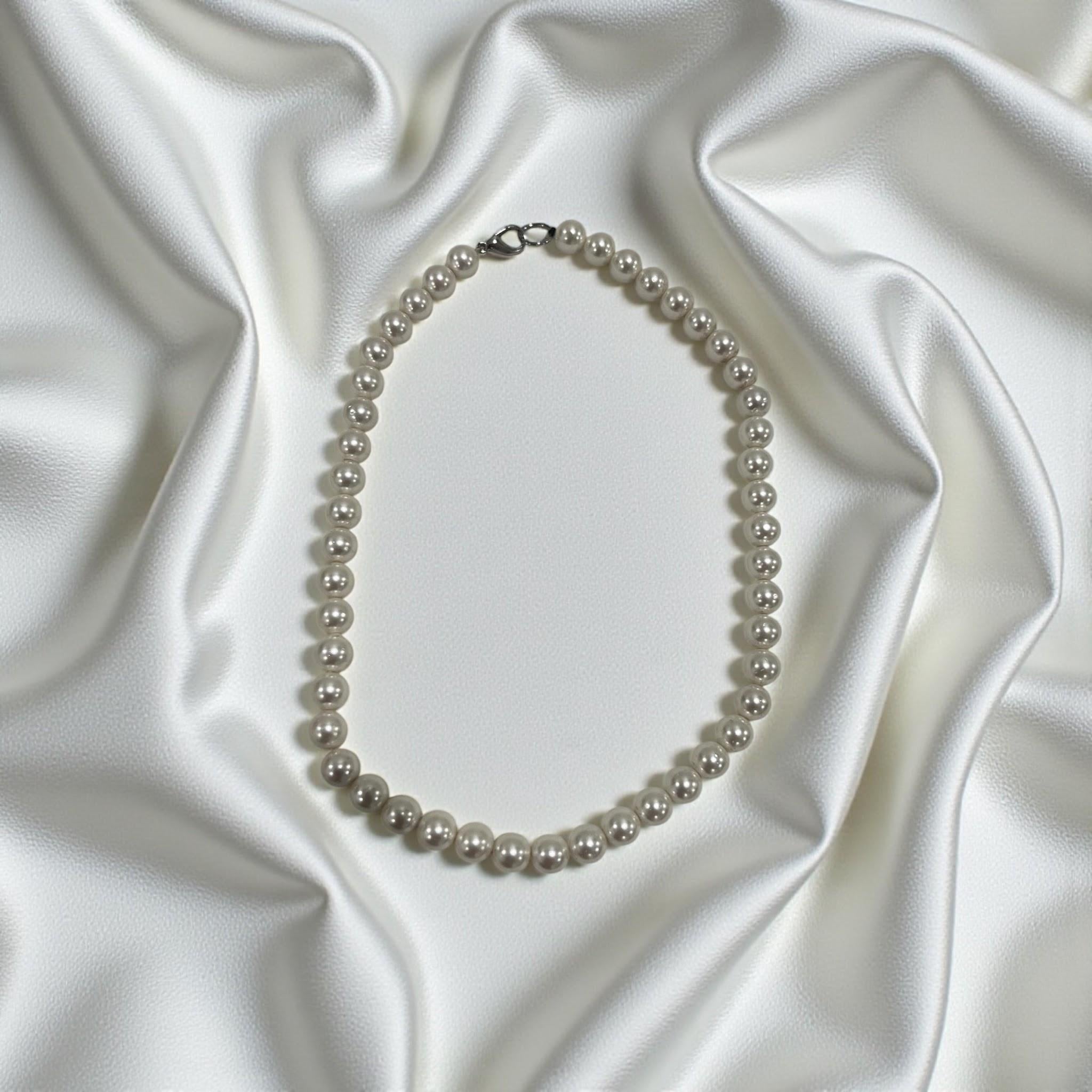 CameroonJewels La Reine Blanche multi-strand genuine freshwater pearl necklace on a white satin background.