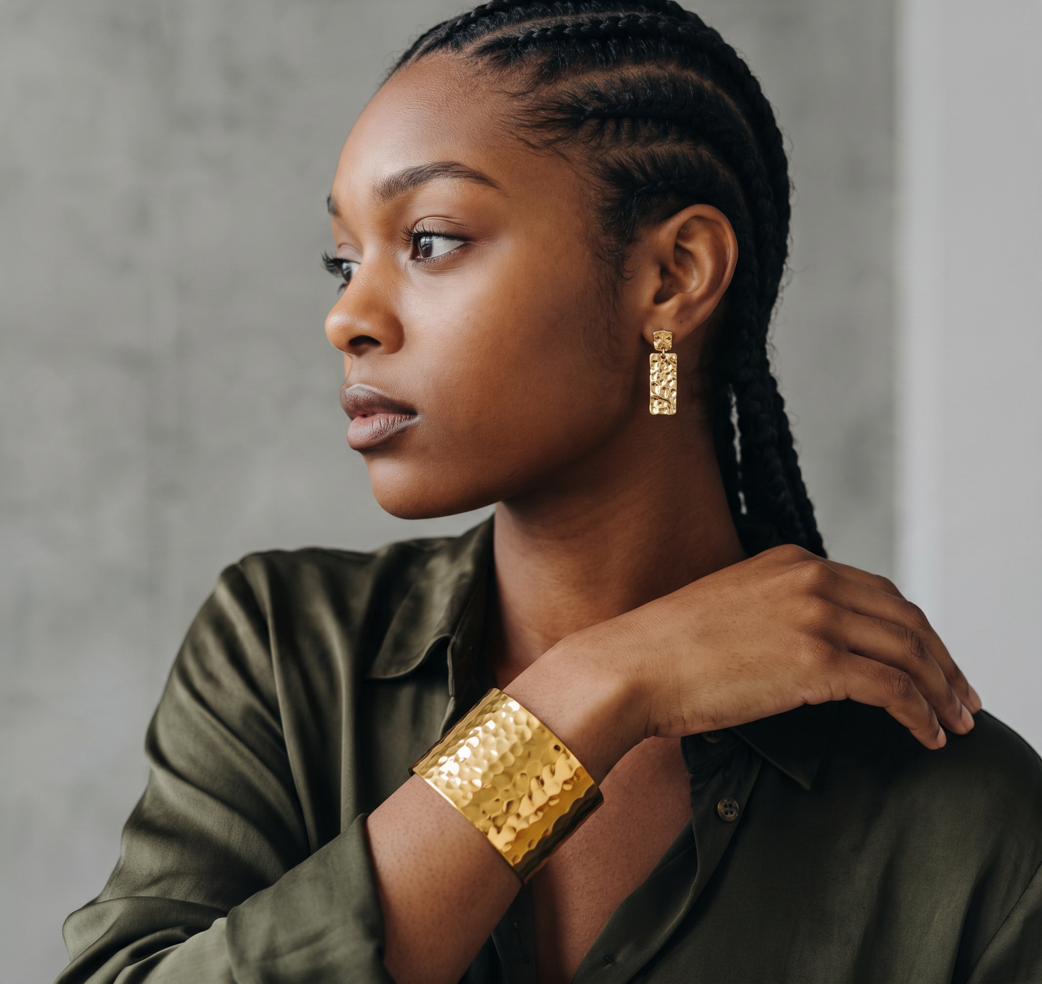 CameroonJewels Maillons d'Or gold-plated cuff bracelet and matching textured earrings worn by a woman in olive shirt