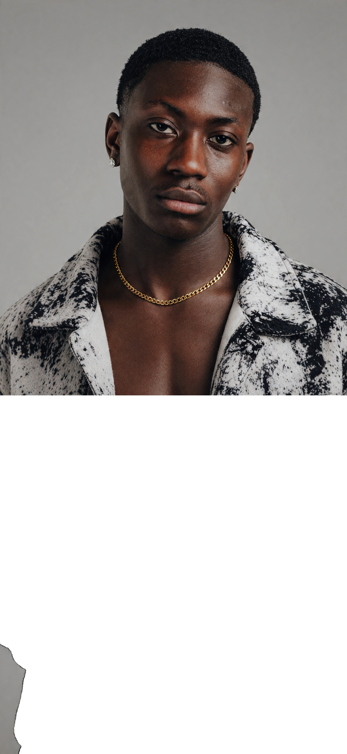 CameroonJewels Chaîne de Gloire 18K gold-plated stainless steel chain necklace worn by a man in a patterned jacket.